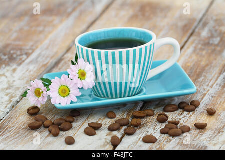 Coffee in vintage cup and pink daisy flowers on rustic wooden surface with copy space Stock Photo