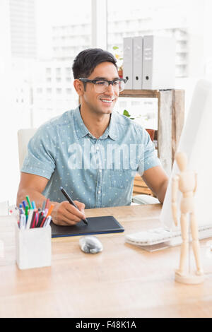 Smiling casual businessman using computer and digitizer Stock Photo