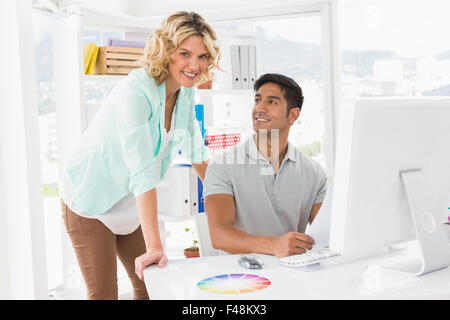 Young smiling business people working at the computers in the office Stock Photo