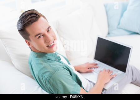 Smiling handsome man using a laptop Stock Photo