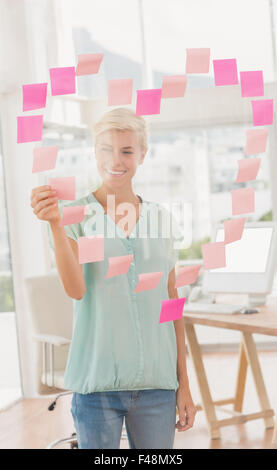 Happy creative businesswoman making a heart with papers Stock Photo