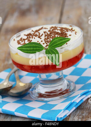 Strawberry trifle in dessert glass on checkered cloth on rustic wooden surface Stock Photo