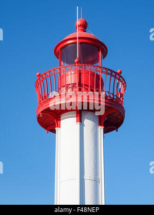 Detail of the high part of a modern marine lighthouse, red head on white column, with clear blue sky Stock Photo
