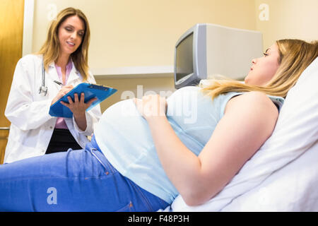 Smiling doctor talking to pregnant patient Stock Photo