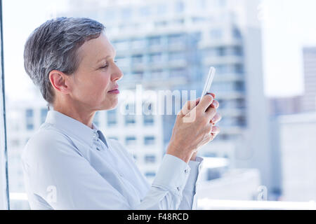 Businesswoman sending a text message Stock Photo
