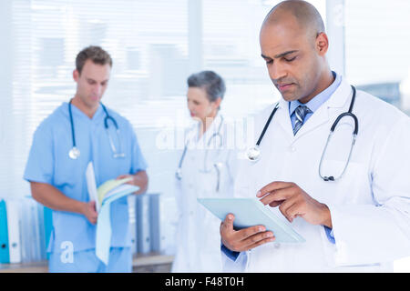 Attentive doctor using his tablet Stock Photo