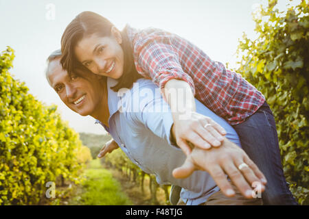 Smiling man carrying woman on his back Stock Photo
