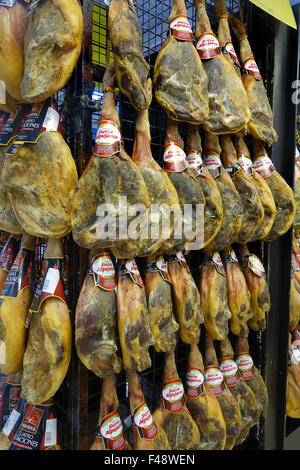 Cured hams Jamon Iberico iberian Ham Hanging in Spain Spanish supermarket Stock Photo