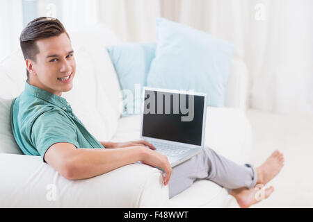 Smiling handsome man using a laptop Stock Photo