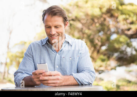 Smiling farmer using a smartphone Stock Photo