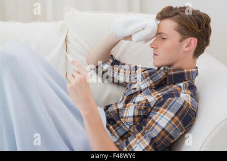 Sick handsome man lying on sofa Stock Photo
