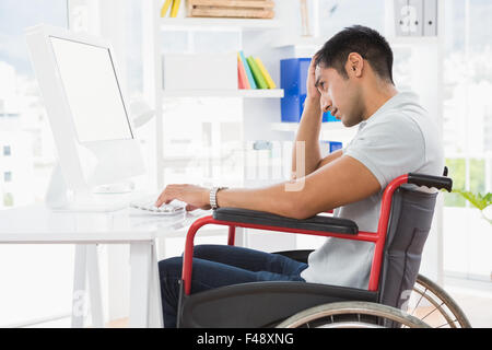 Young thoughtful businessman looking at his computer screen Stock Photo