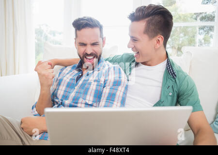 Homosexual couple men looking at laptop Stock Photo