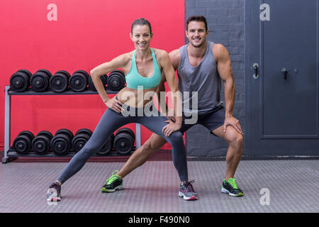 Muscular couple doing leg stretchings Stock Photo