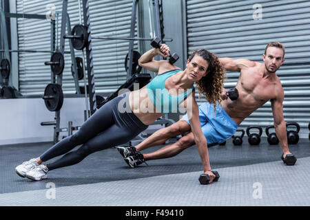 Muscular couple doing side plank Stock Photo