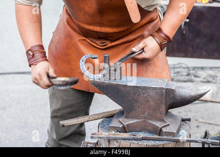 Blacksmith handles the horseshoe on the anvil Stock Photo