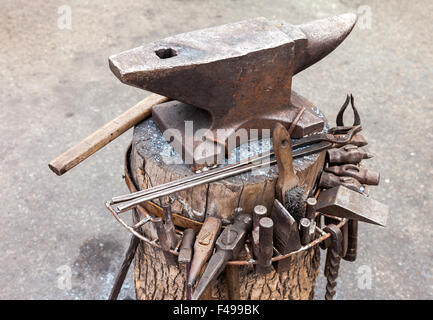 Old anvil with blacksmith tools on the outdoors Stock Photo