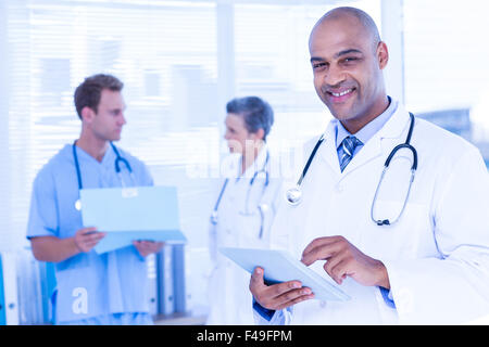 Smiling doctor using his tablet Stock Photo