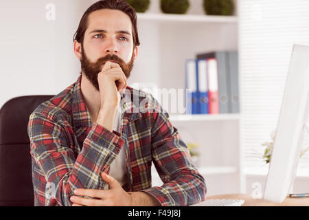 Hipster businessman sitting at his desk Stock Photo