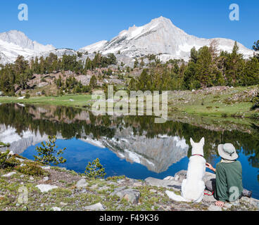 Hiker and dog relax at 20 Lakes Basin in the Eastern Sierra Stock Photo