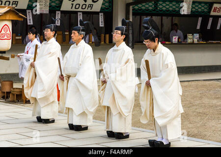 Nishinomiya shrine, Japan, Shinto Priest ceremony, Five kannushi, all wearing Kammuri black hats and holding shaku, small wooden staffs. Stock Photo