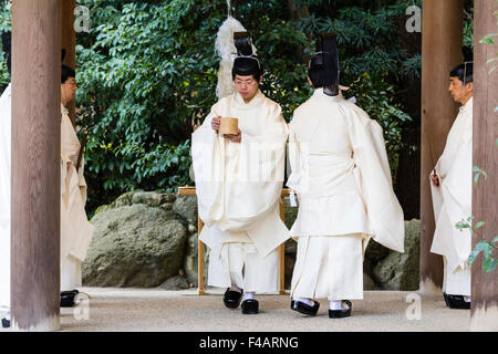 Nishinomiya shrine, Japan, Shinto Priests, Kannushi, with chief priest making offerings to four other priests. All wear Kammuri, black hats. Stock Photo