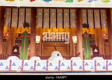 Nishinomiya shrine, Japan, New Year ceremony. View through screen of a row of Priests, kannushi, all wearing Kammuri hats, in the Honden, sanctuary. Stock Photo