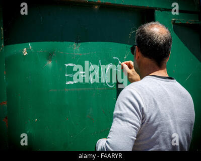 Man writing E=MC2  Albert Einstein's theory of special relativity on the side of a metal sheet Stock Photo