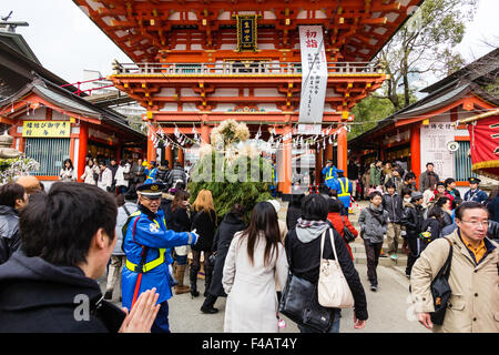 Japan New year. Crowd moving through main gate to visit Ikuta Shrine at Kobe, with foreground Kadomatsue, new year traditional decoration, gate pine. Stock Photo
