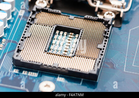 Motherboard of computer, with an empty Intel 1156 socket processor base, open showing the processor pin array before the processor is fitted. Stock Photo