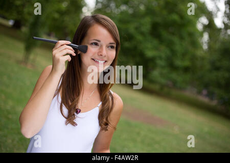 A young woman putting on make up Stock Photo
