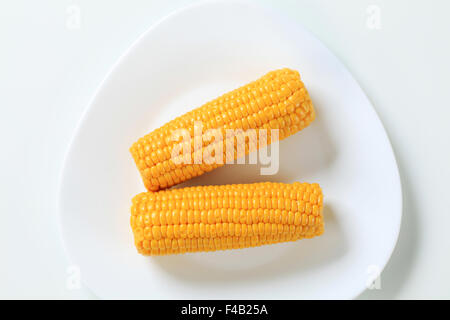 two boiled corn cobs on white plate Stock Photo