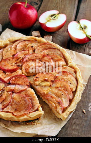 Fruit apple pie over baking paper on rustic table Stock Photo