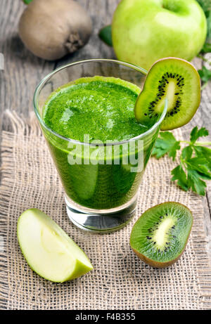 Green smoothie in glass on rustic table Stock Photo