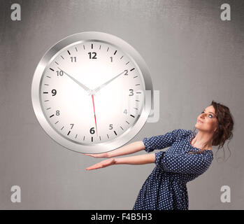 Attractive lady holding a huge clock Stock Photo