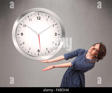 Attractive lady holding a huge clock Stock Photo