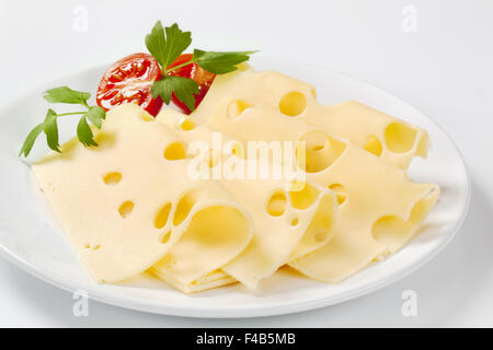 thin slices of emmental cheese on white plate Stock Photo