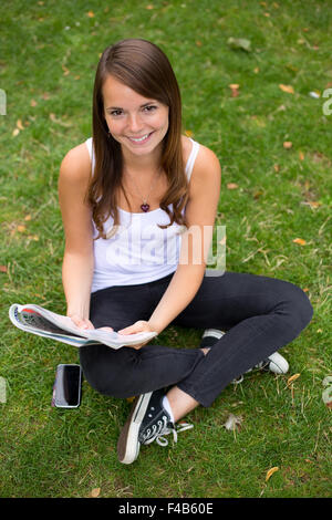 young woman in the park with a magazine Stock Photo