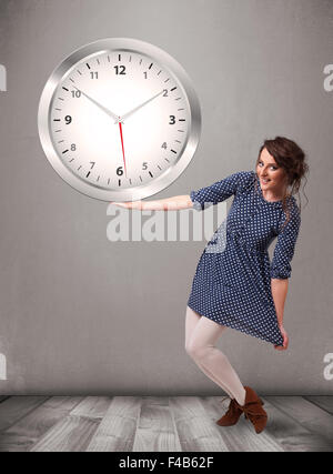 Attractive lady holding a huge clock Stock Photo