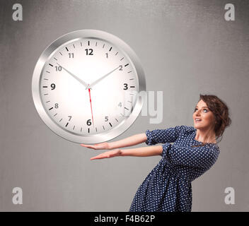 Attractive lady holding a huge clock Stock Photo