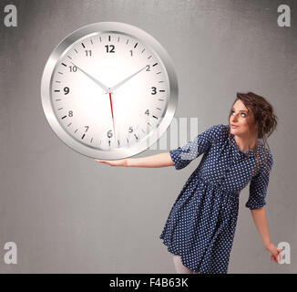 Attractive lady holding a huge clock Stock Photo