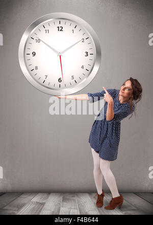 Attractive lady holding a huge clock Stock Photo