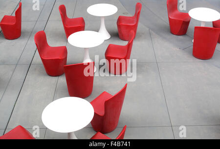 Plastic red chairs and white tables on concrete patio in San Francisco, California Stock Photo