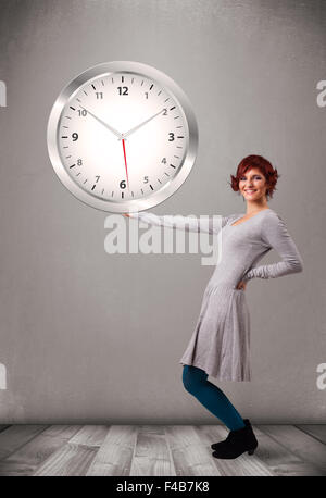 Attractive lady holding a huge clock Stock Photo