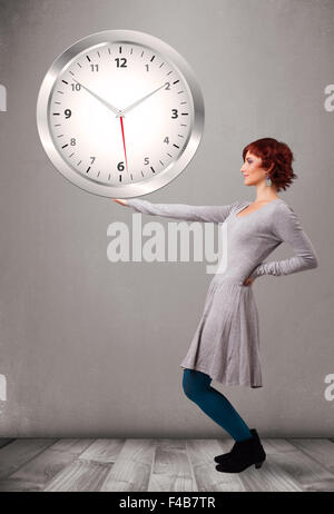 Attractive lady holding a huge clock Stock Photo