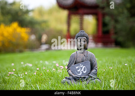 Om Sign with Buddha Statue Stock Photo