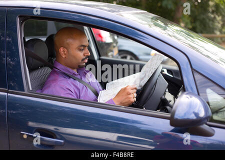 man sitting in his car reading a map Stock Photo