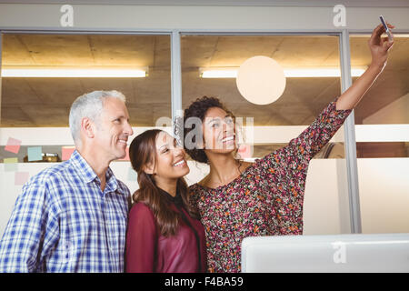 Businesswoman taking selfie of colleagues Stock Photo