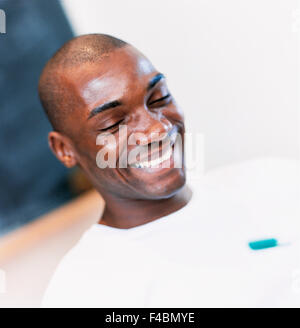 Closeup of dark-skinned guy in white sweater. Stock Photo