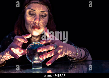 Serious female fortune teller with crystal ball Stock Photo